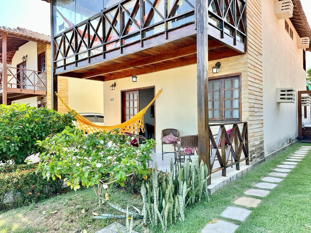 Fachada térrea com jardim e rede na varanda